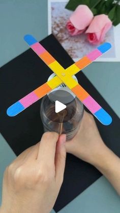 a person is holding a plastic toy that looks like a propeller