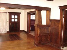 an empty living room with wood floors and wooden doors on either side of the doorway