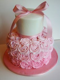 a pink and white cake decorated with roses