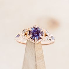 an engagement ring with a blue and white diamond surrounded by two smaller diamonds on top