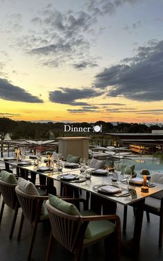 an outdoor dining area with tables, chairs and place settings for dinner at sunset or dawn