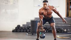 a man holding a kettle while standing in a gym