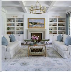 a living room with two couches and a coffee table in front of a fireplace