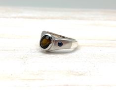 "Hi everyone, just wanted to let you know we are open and shipping daily. Beautifully crafted \"one of a kind\" contemporary Sterling Silver ring with genuine chrome tourmaline and Sapphire stones. The silver ring is finished with Rhodium so it will not tarnish. The gemstone used in this ring has been hand picked on a recent trip to Bangkok and is of a quality usually reserved for fine jewelry so you will almost never find such nice stones set in sterling silver! Weight 8 Grams This fine jewelry Modern Sterling Silver Birthstone Ring With Accent Stones, Modern Green Sapphire Ring, Modern Silver Birthstone Ring, Modern Birthstone Ring With Polished Finish, Modern Sterling Silver Emerald Ring, Modern Tourmaline Emerald Ring As Gift, Modern Sterling Silver Emerald Ring With Bezel Setting, Modern Tourmaline Rings For Gift, Modern Tourmaline Rings As Gift