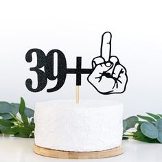 a cake topper with the number thirty and a hand pointing at it on a wooden stand