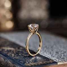 a gold ring sitting on top of an open book