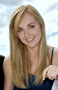 a woman with long blonde hair smiling at the camera