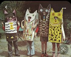 four people are dressed up as cats in the shape of paper machs and holding scissors