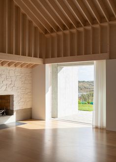 an empty room with a fireplace and sliding glass doors that lead out to the outdoors