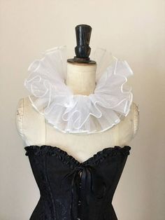 a black corset with white ruffles on it