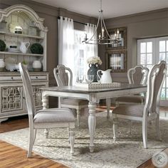 a dining room table and chairs in front of a window