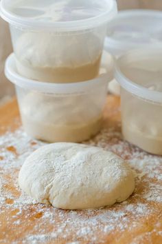 a doughnut sitting on top of a wooden table next to plastic containers filled with powdered sugar