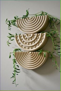 three ceramic bowls with green stems on the sides and one is shaped like spirals