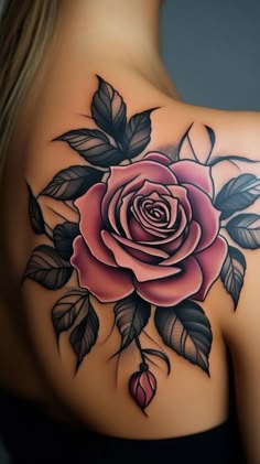 the back of a woman's shoulder with a rose and leaves tattoo on it