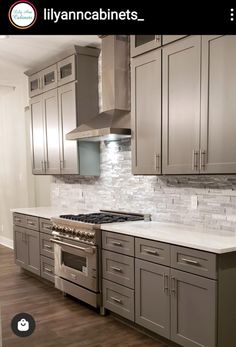 a kitchen with gray cabinets and white counter tops