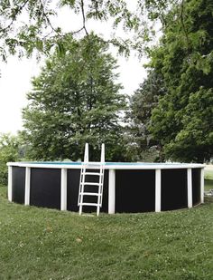 an above ground swimming pool with ladder in the grass