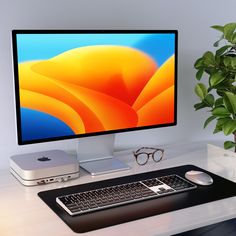 a computer monitor sitting on top of a desk next to a keyboard, mouse and eyeglasses