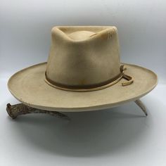 Western 50x in Sahara with custom distressing Teardrop crown Kettle curl on 3" brim Layered Elk leather accent bands Whipstitch on crown and brim Hand stitched Tonal Mountain detail Custom hand stitched initials upon request. This felt hat is made to order, please allow 6-8 weeks for delivery. Vintage Distressed Brown Hat For Country Events, Classic Distressed Brown Hat With Short Brim, Vintage Fedora With Flat Crown, Classic Hat With Curved Brim In Distressed Brown, Vintage Distressed Brown Hat With Curved Brim, Classic Distressed Brown Hat With Curved Brim, Vintage Distressed Brown Hat For Rodeo, Vintage Leather Fedora For Rodeo, Vintage Fitted Felt Hat For Ranch