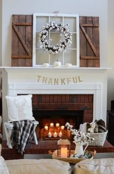 a living room with a fireplace decorated for thanksgiving and a wreath on the mantel