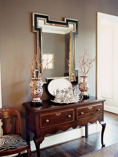 a table with a mirror and vases on it