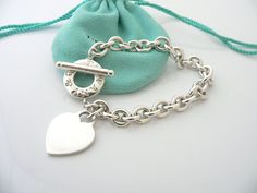 Overview:Offered for sale is a wonderful and gorgeous Tiffany & Co. Sterling Silver Heart Toggle bracelet. Definitely a Tiffany piece that you will get your money's value for. It works perfectly with pretty much any attire your put on, AND is a great statement piece. The chain for this specific bracelet is quite substantial, and the pretty Tiffany heart just goes perfectly with it. It is the perfect bracelet that fits a lifestyle on the go -- can be worn to pretty much any occasion! It is si Luxury Valentine's Day Charm Bracelet, Elegant Heart Bracelet With Toggle Clasp For Valentine's Day, Elegant Valentine's Day Bracelets With Toggle Clasp, Elegant Heart Bracelet With Toggle Clasp For Gift, Valentine's Day Gift Bracelet With Toggle Clasp, Valentine's Day Heart Bracelet With Toggle Clasp, Valentine's Day Gift Heart Bracelet With Toggle Clasp, Gift Love, Toggle Bracelet