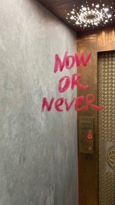 graffiti is spray painted on the wall next to a door in an elevator area that says, now or never