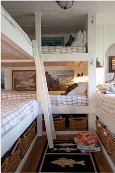 two bunk beds in a room with baskets on the floor and other items under them