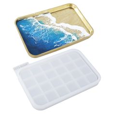 an ice tray with a cell phone in it and the lid opened to show water inside