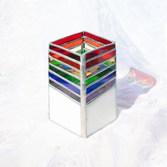 a multicolored glass vase sitting on top of a white surface