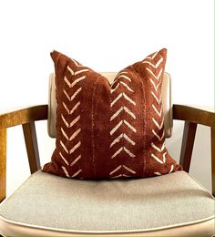 a brown and white pillow sitting on top of a wooden chair