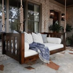 a porch swing with pillows on it