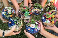 several people holding small glass bowls filled with plants