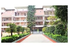 an apartment building with trees and bushes surrounding it