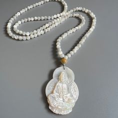 Mother Of Pearl Guanyin, Kuan Yin, Quan Yin, Kwan Yin Healing Buddha Pendant Bodhisattva Pendant Buddha Necklace Gifts For Mom & Grandma Guanyin, a venerated figure in Buddhism, embodies the essence of compassion and mercy. Revered as the Goddess of Mercy in Buddhism, Guanyin, also known as Avalokitesvara, is a beacon of hope, guiding countless devotees through life's tumultuous seas with her boundless empathy and wisdom. Her image, gracefully depicted in countless temples and shrines across Chi White Amulet Jewelry For Meditation, Goddess Kuan Yin, Yin Yang Pearl Necklace, Guan Yin Statue, Buddha Pendant Necklace, Goddess Of Mercy, Quan Yin, Kwan Yin, Kuan Yin