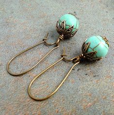 "These charming earrings were made with semi-precious gemstone beads of Magnesite in teal green with brown veins. I embellished the stones with antiqued solid brass caps to add a touch of stylish vintage look. They dangle from antiqued solid brass kidney ear-wires. All metal materials are lead-safe. Lovely pieces. Length: approx. 1-5/8\" (from the top curve of ear-wires) Condition: new Materials: Magnesite (10mm round) beads, Lead safe metal caps, findings, and ear-wires (brass) ❥ With a \"Hand Vintage Turquoise Earrings With Round Beads, Bohemian Jade Wire Wrapped Earrings, Vintage Brass Earrings With Natural Stones, Vintage Teardrop Earrings With Natural Stones, Handmade Turquoise Jade Earrings, Vintage Teardrop Natural Stone Earrings, Vintage Green Wire Wrapped Jewelry, Drilling Glass, Work Earrings