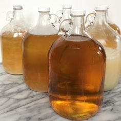 several bottles of liquid sitting on top of a marble counter