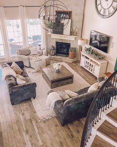 a living room filled with lots of furniture and a spiral staircase leading up to the second floor