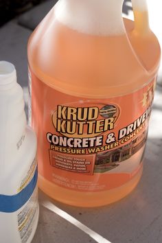 a bottle of krud kutter concrete and driveway cleaner next to a gallon of liquid