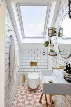 a white toilet sitting under a bathroom window next to a sink and bathtub in a bathroom