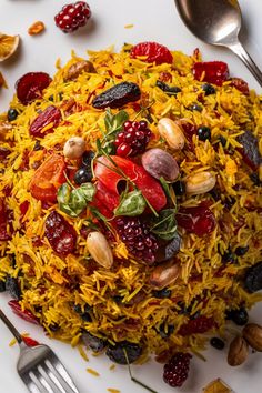 Saffron rice pilaf garnished with various dried fruits, nuts, and fresh herbs on a white plate, with cutlery on the side. Persian Basmati Rice, Arabian Rice Recipes, Persian Rice Recipe Basmati, Persian Jeweled Rice, Persian Food Iranian Cuisine, Jeweled Rice, Persian Chicken, Rice Dishes Recipes, Middle Eastern Food