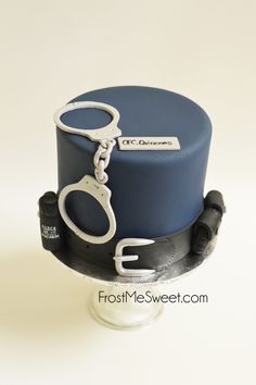 a blue and black cake with handcuffs on top