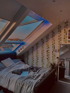 a bed sitting under a skylight in a bedroom next to a wall with plants on it