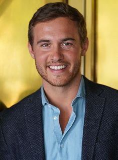 a man in a blue shirt and jacket smiling