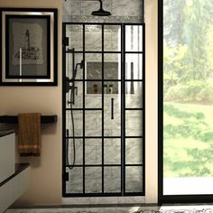 a bathroom with a glass shower door and framed pictures on the wall next to it