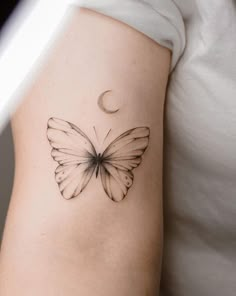 a butterfly with a crescent moon tattoo on the left side of the arm and shoulder