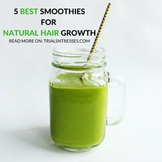 a green smoothie in a mason jar with a straw sticking out of the top