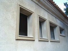 three windows on the side of a building