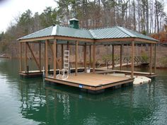 a boat dock with a ladder on it in the middle of a body of water