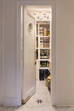 an open door leading to a pantry with lots of food in it and spices on the shelves