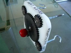 a clock with gears attached to it sitting on a glass table